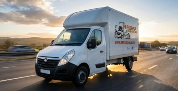 A uniformed RB Removals professional safely loading a moving box into a dedicated transport van for a long-distance UK relocation.